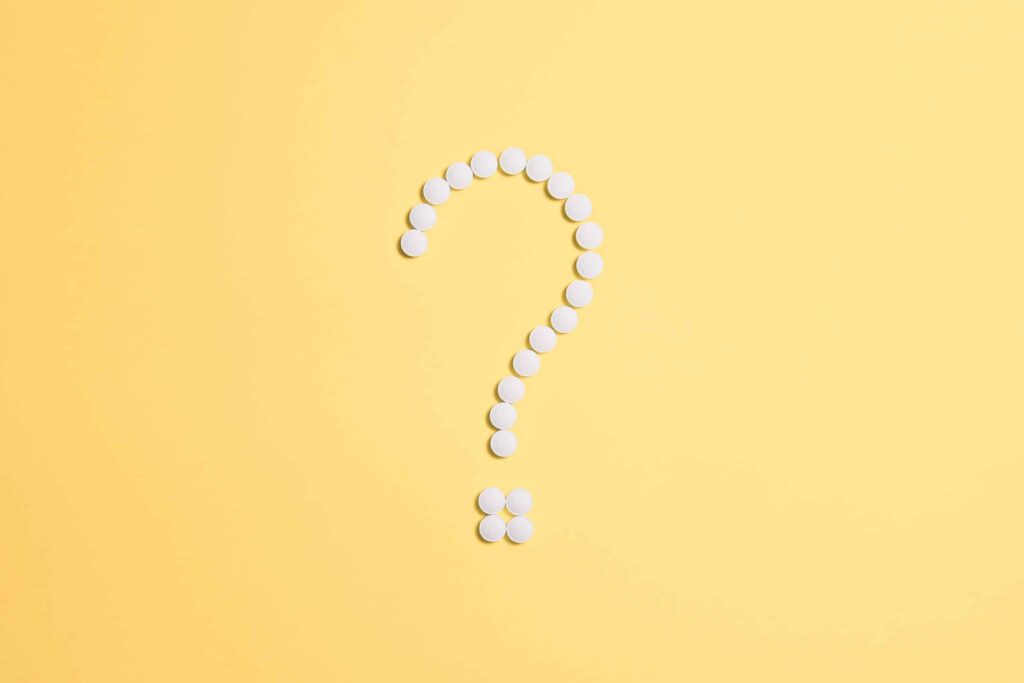 alcohol rehab covered by umr, a yellow background with pills laid in the shape of a question mark